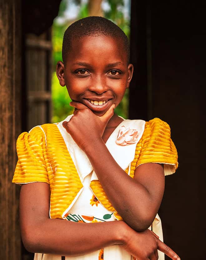A child smiling confidently to the camera.