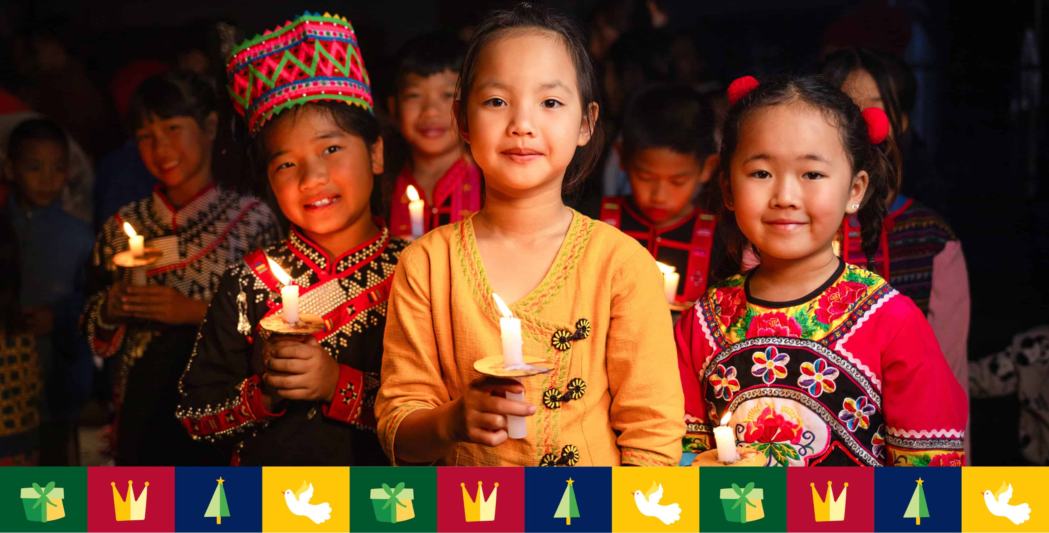A group of children each holding a candle in their hands and smiling to the camera.