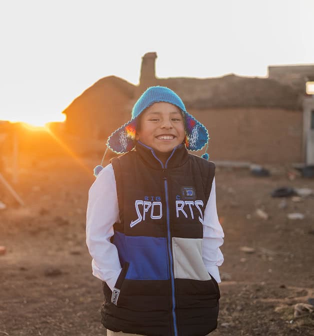 A child smiling confidently to the camera.