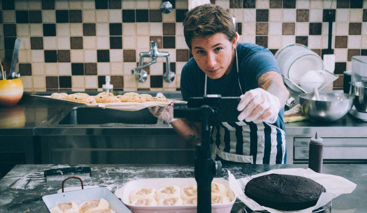 Man taking selfie while holding pre-baked goods.