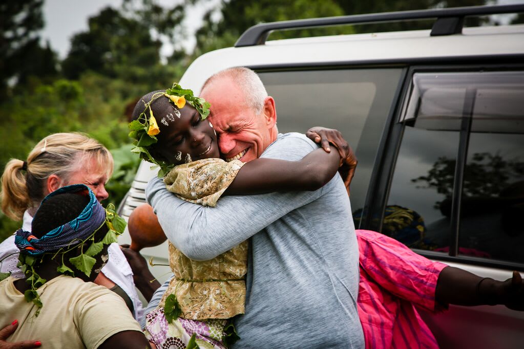 Violet, who is wearing traditional dress gives her sponsor a big hug, as the sponsor cries of joy