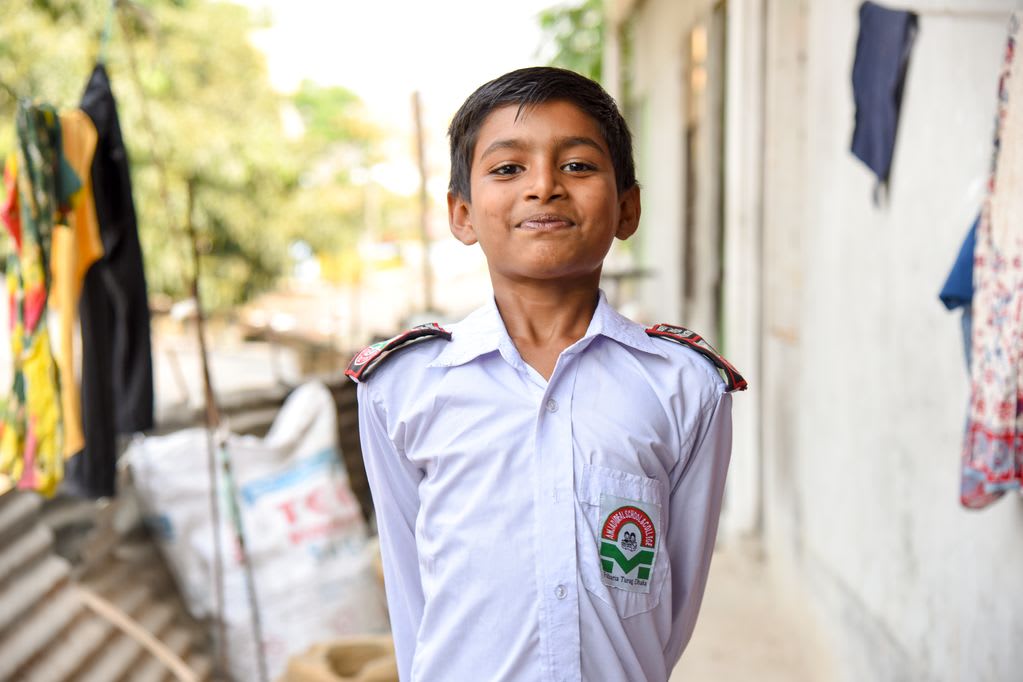 A male child, boy, Pranto is happy to show off his white school uniform, in which he looks his best!