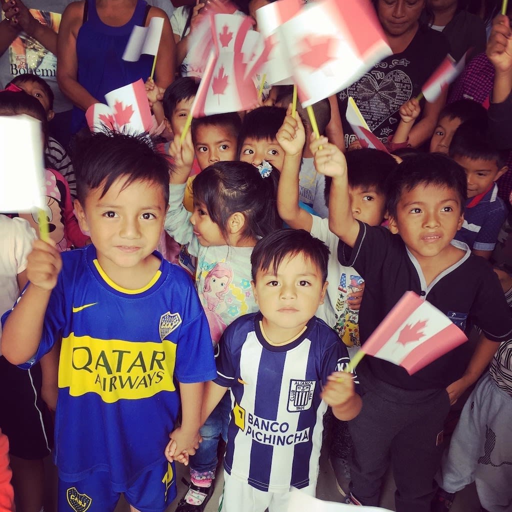 Children from Ecuador wave Canadian flags