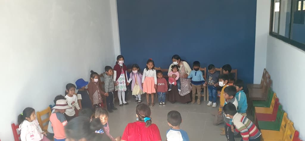 A group of young children stand in a sunday school classroom.