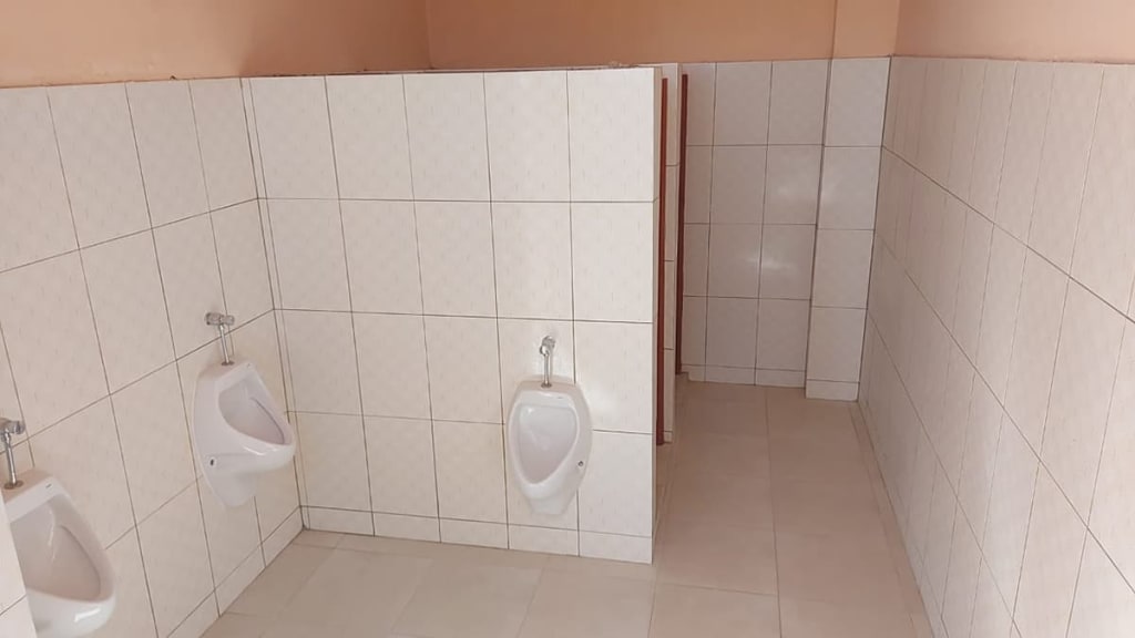 Finished men's bathroom with white tile and urinals