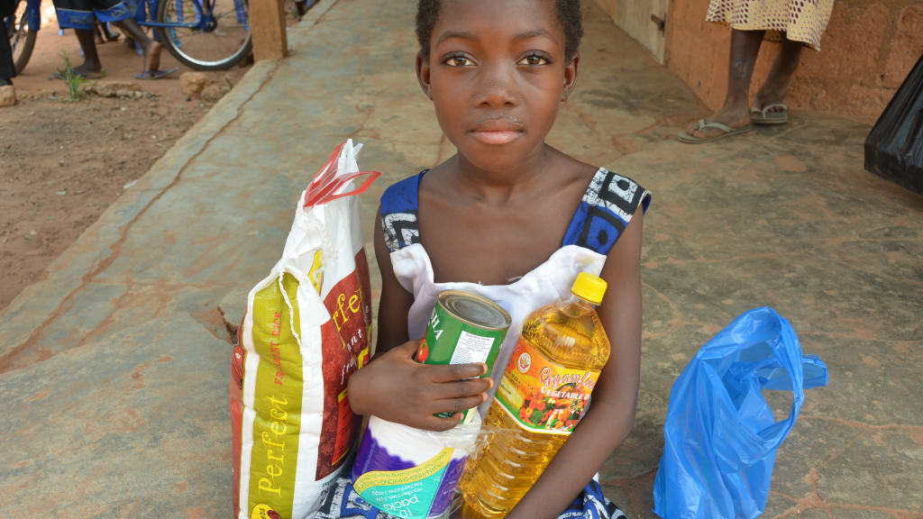 Rejoice Sicikwa Letsu happily holds her gifts of food and vegetable oil in a close-up during the special event Christmas party celebration