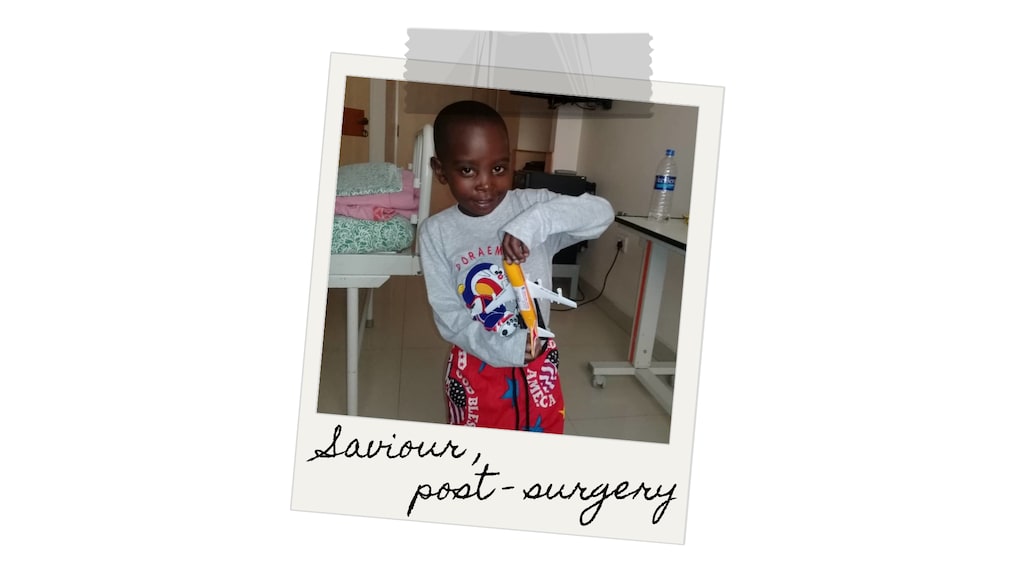 Saviour holds stands in his hospital room, playing with a toy airplane.