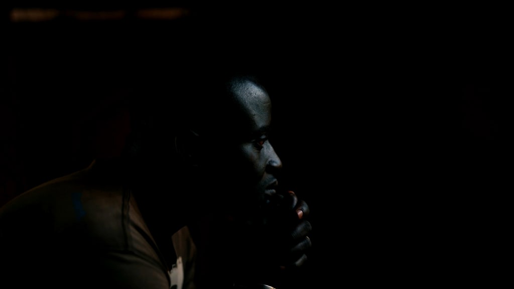 A man sits in the dark.