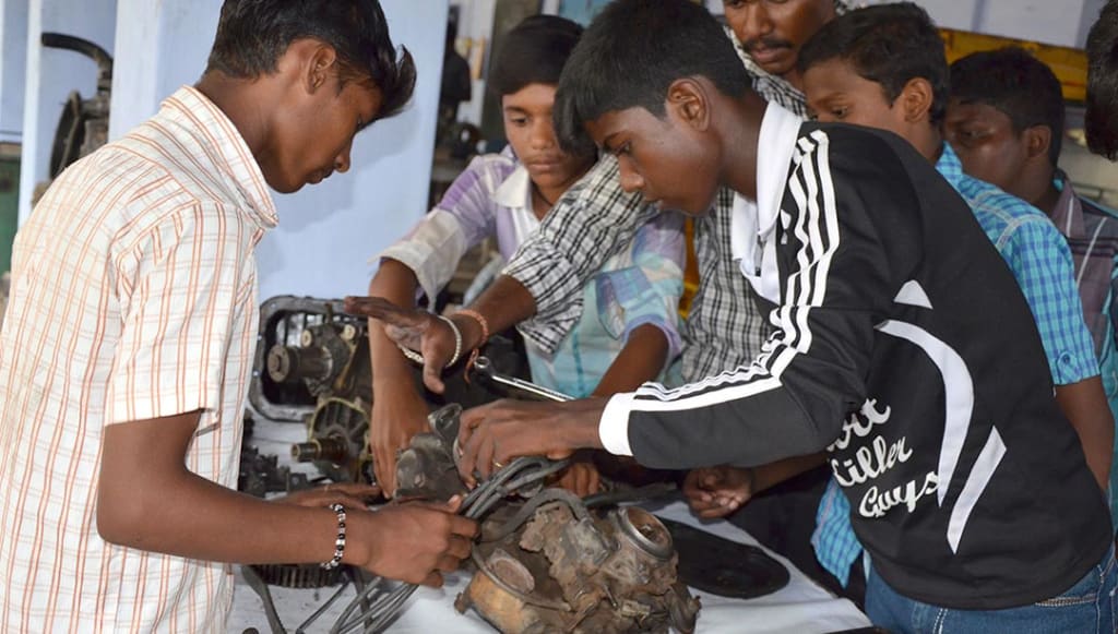 Indian teenagers work on a small motor.