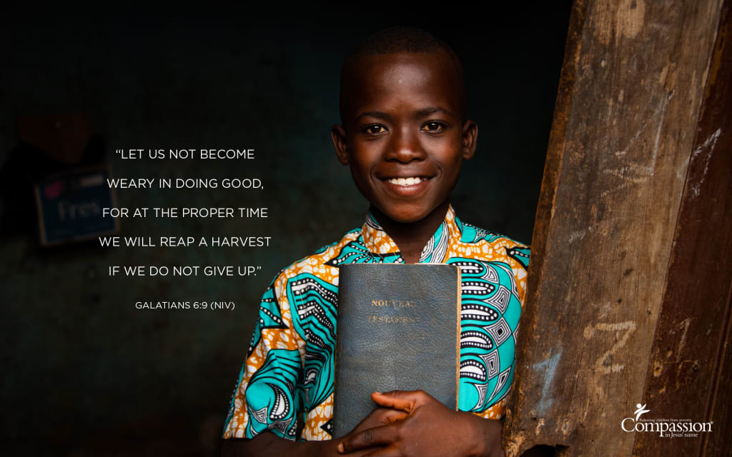 A photo of a boy in Togo holding a Bible, with the text of Galatians 6:9 overlaid on the image.