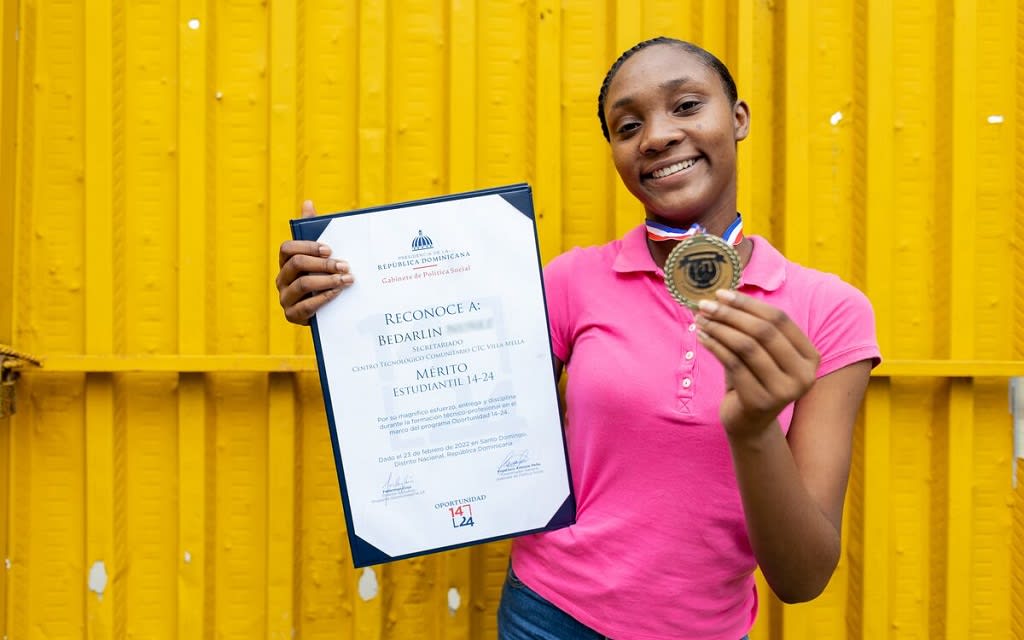 Girl holding up her certificate and medal