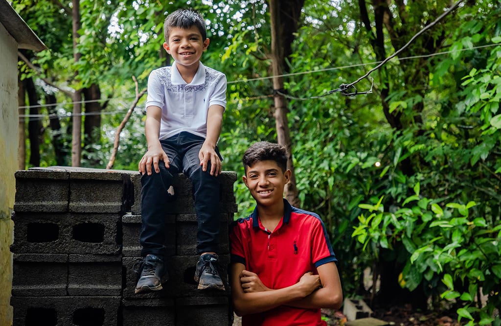 Joseph, 8 (left), and Holman, 15 (right), outside of their home.