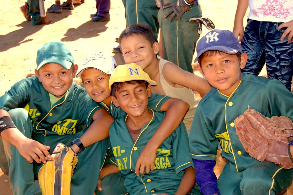 A group of boys wearing green jerseys smiling at the camera