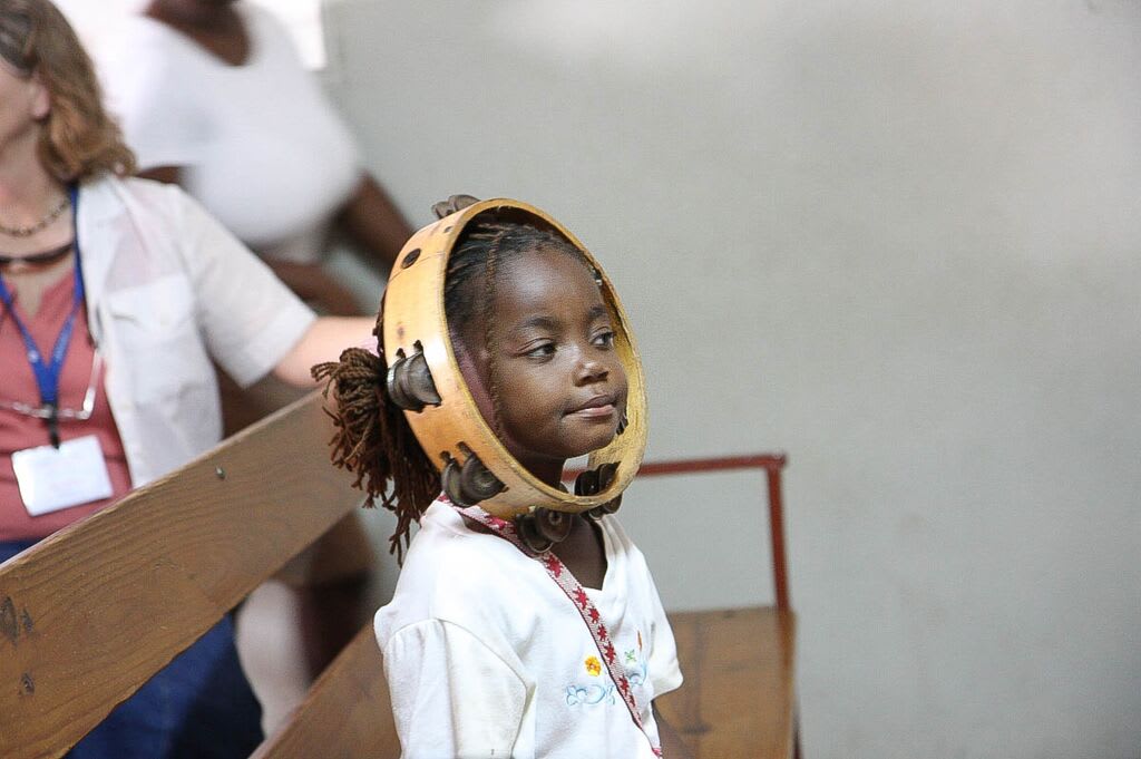 Little girl smiles with a tambourine on her head