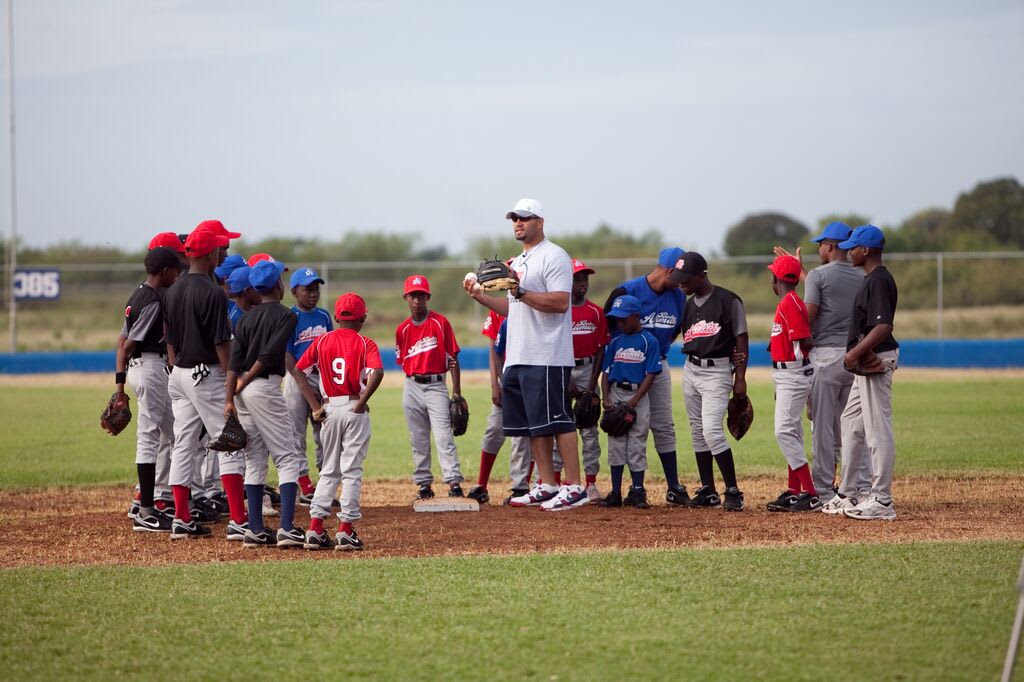 Albert standing in the field with young baseball players