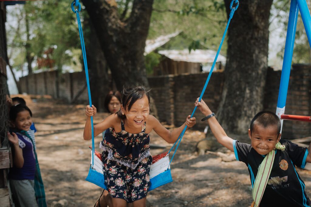 Children playing on a swing set at their Compassion centre.