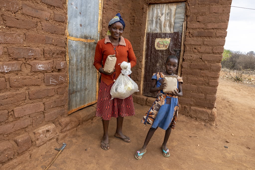 Mother and daughter holding food packs
