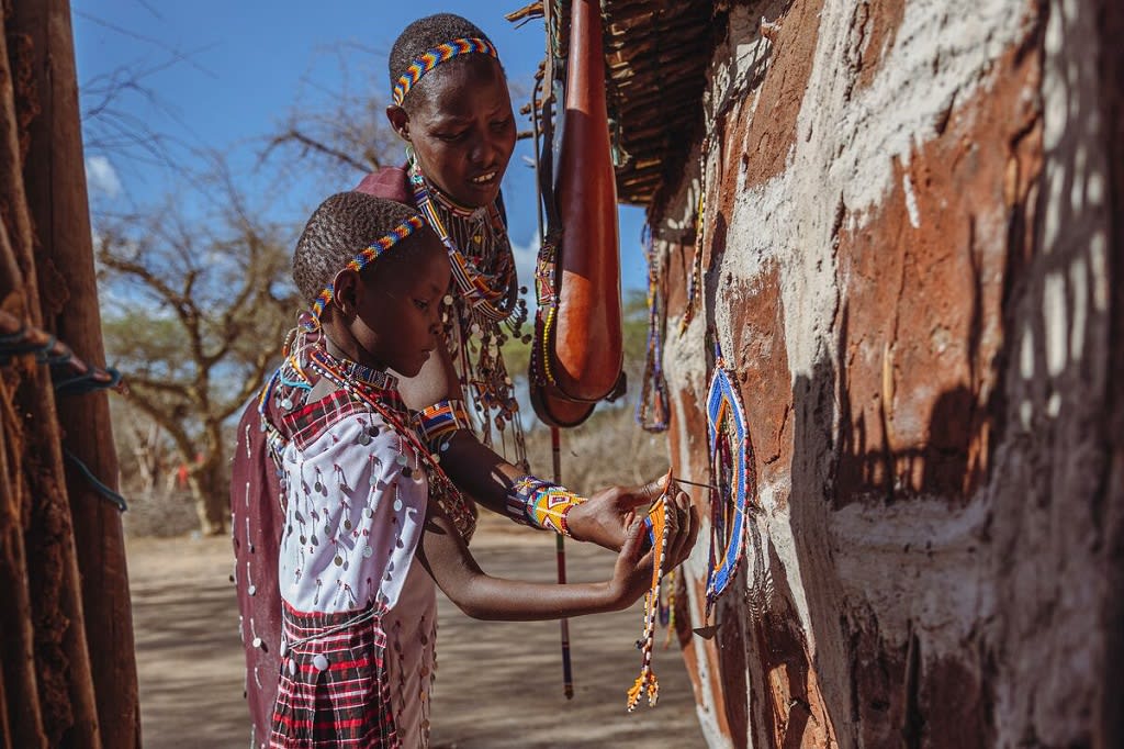 Little girl is decorating her home with beaded works along with her mother