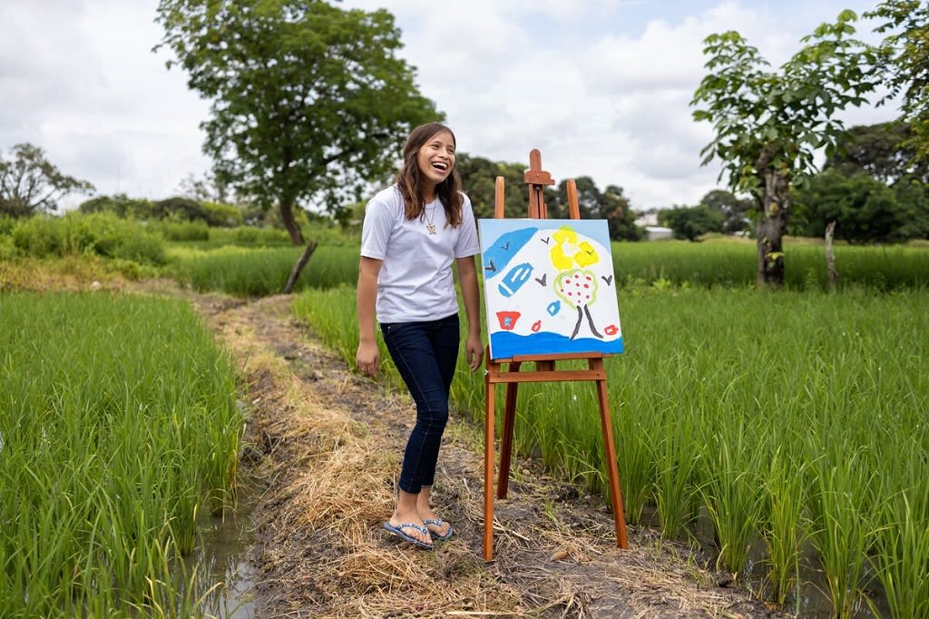 Girl standing beside her painting