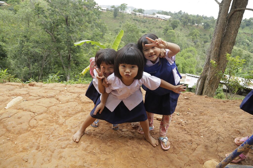Three little girls pose with peace signs for the camera