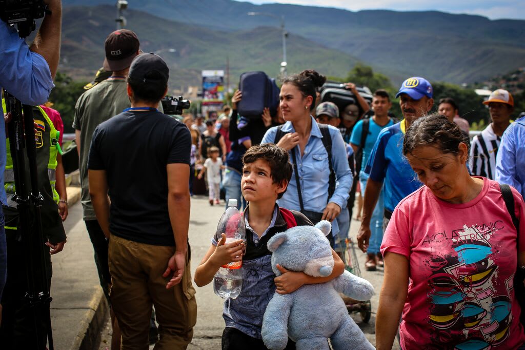 Little boy holding a teddy bear crossing the border