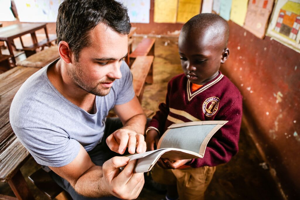 Sponsor is visiting his child and reading a book to him.