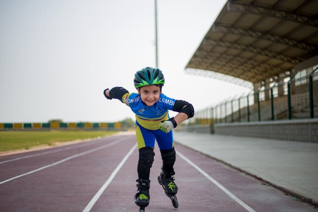 A young boy skating on a track.