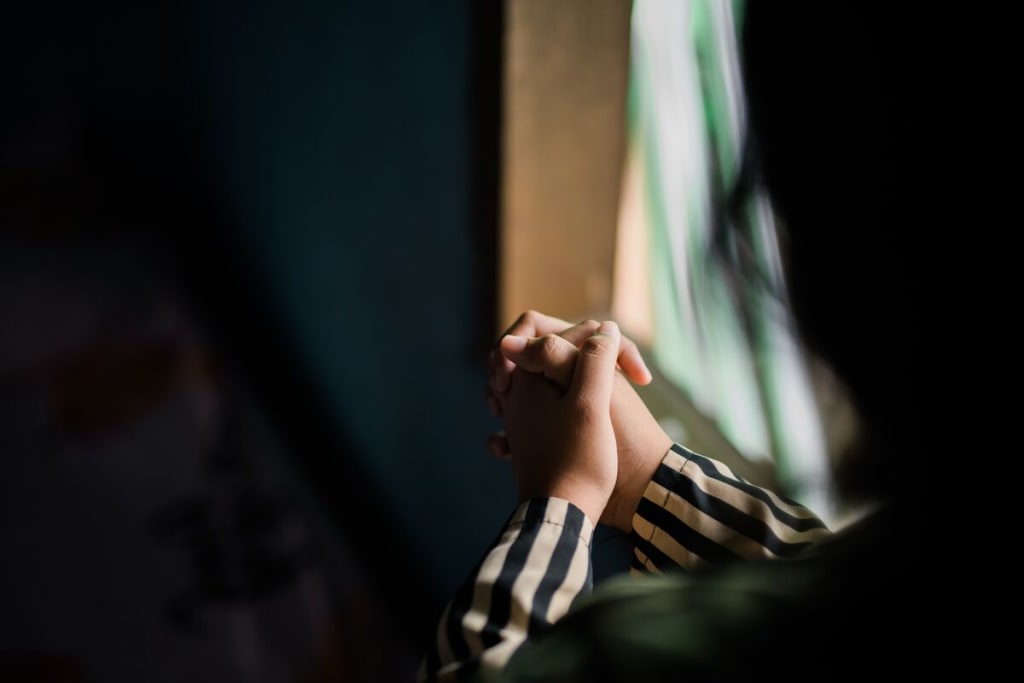 A close up of a girl's hands praying