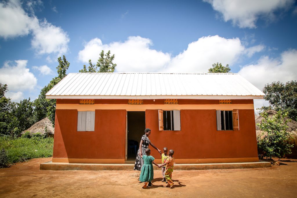 Annet and her triplets after they received their new home over two years ago.