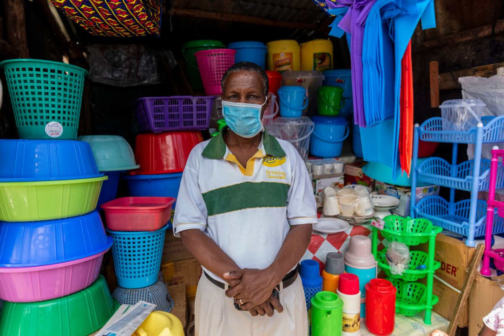 Man wearing a blue mask stands in front of a pile of colourful baskets