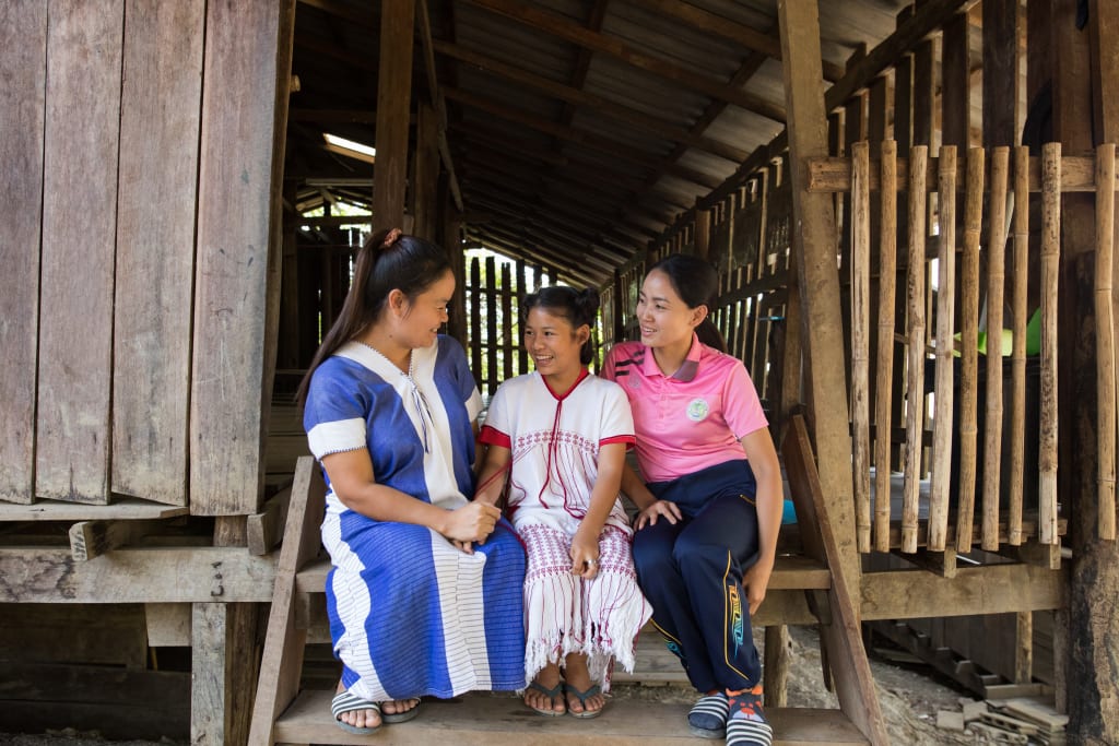 Kannika, centre director, and Nat, mentor, are two of the women at the Compassion centre who are building into Thidarat’s life. They sit on the steps laughing together.