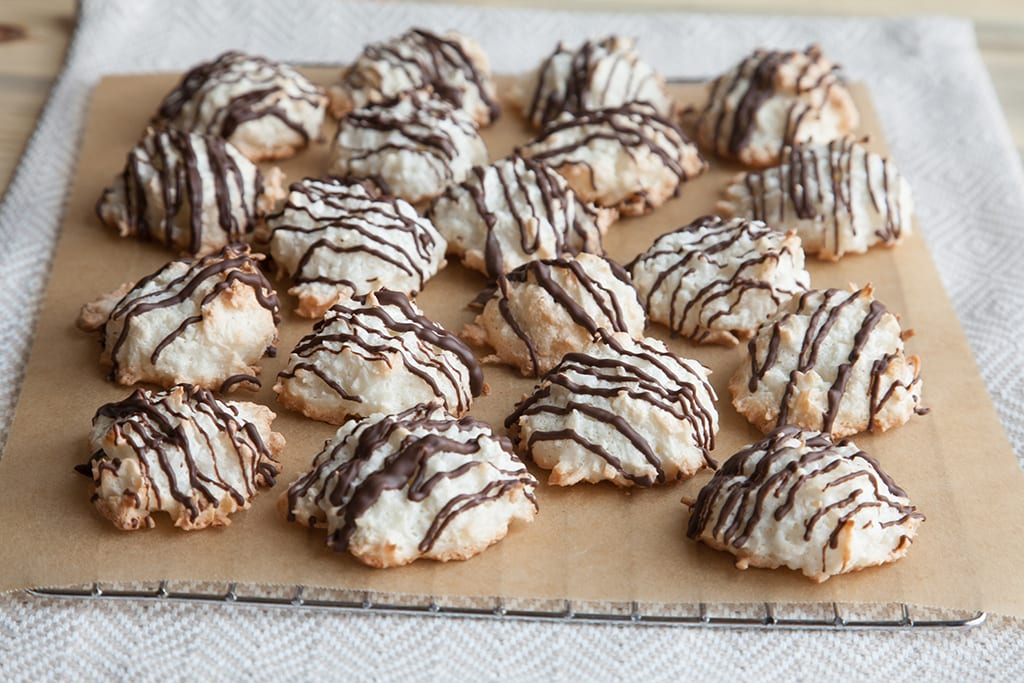 Cookies drizzled with chocolate sitting on a cooling rack.