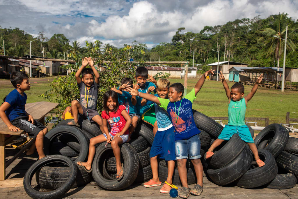 Chaci children play on a stack of tires