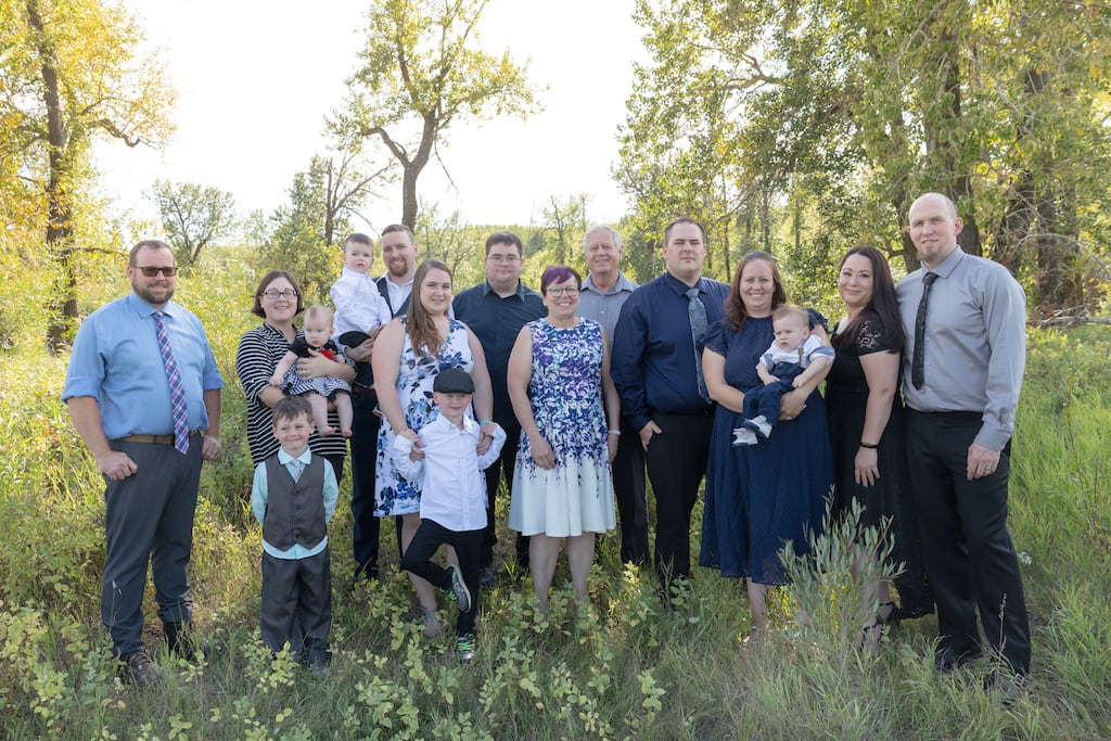 Lynn's entire family is pictured in a field surrounded in trees.