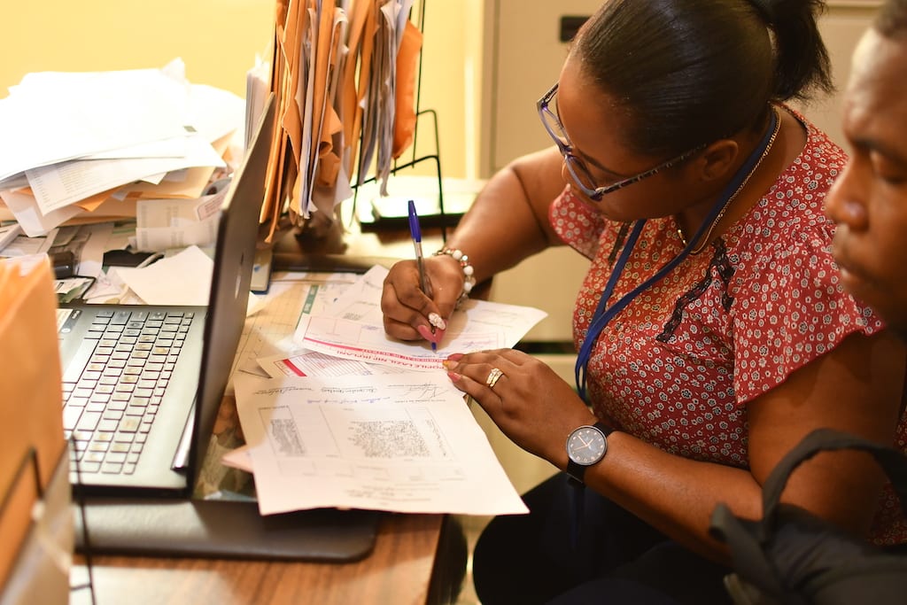 In Haiti, Compassion staff member Marie Rose fills out a form.