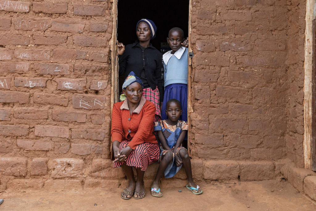 A Kenyan family in the doorway of their brick home.