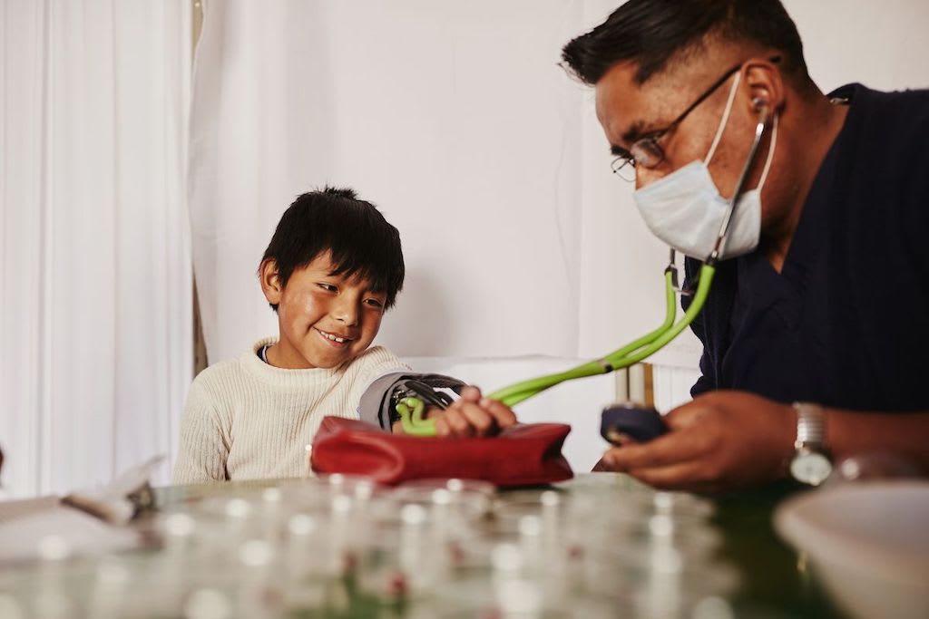 A doctor examines a young boy in Bolivia.