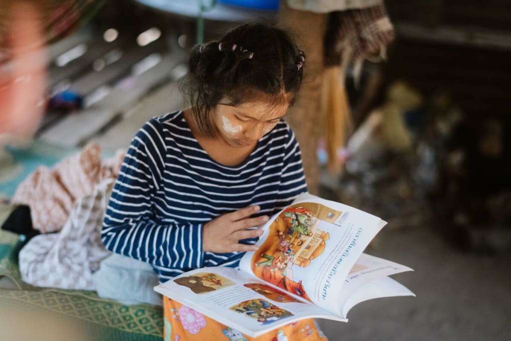 A young girl in Thailand reading a book