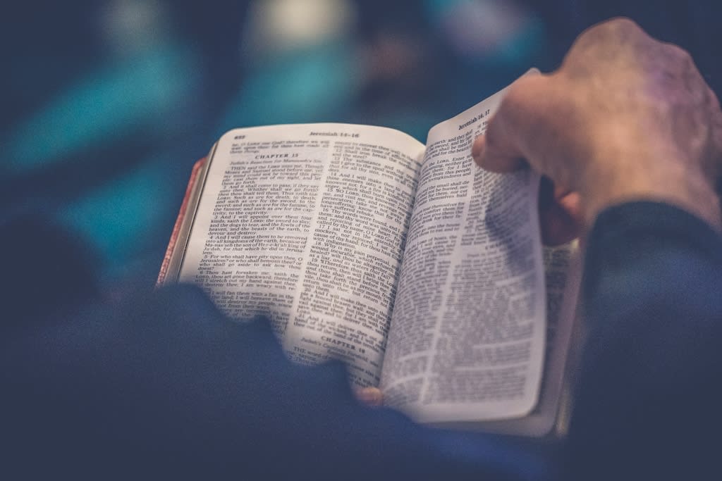 A closeup of a hand flipping through a Bible.
