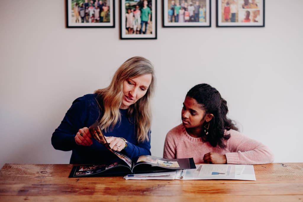 A mother and daughter look through a photo book.