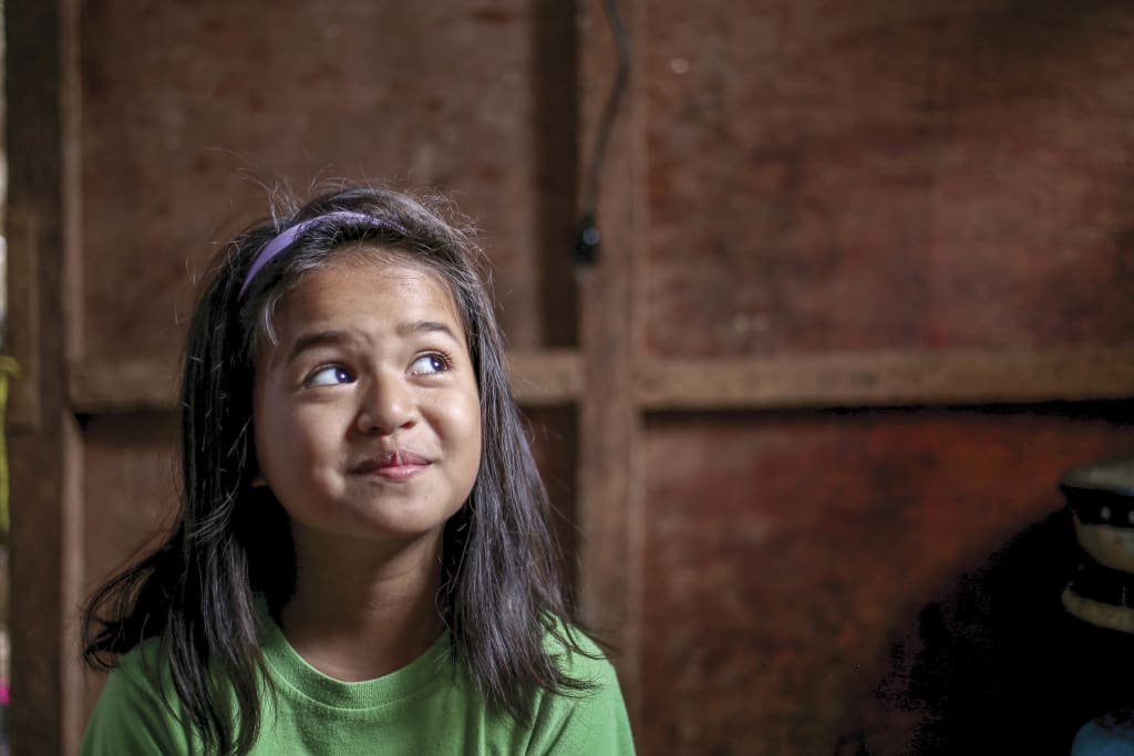 10-year-old girl makes a silly face to the camera in her house.