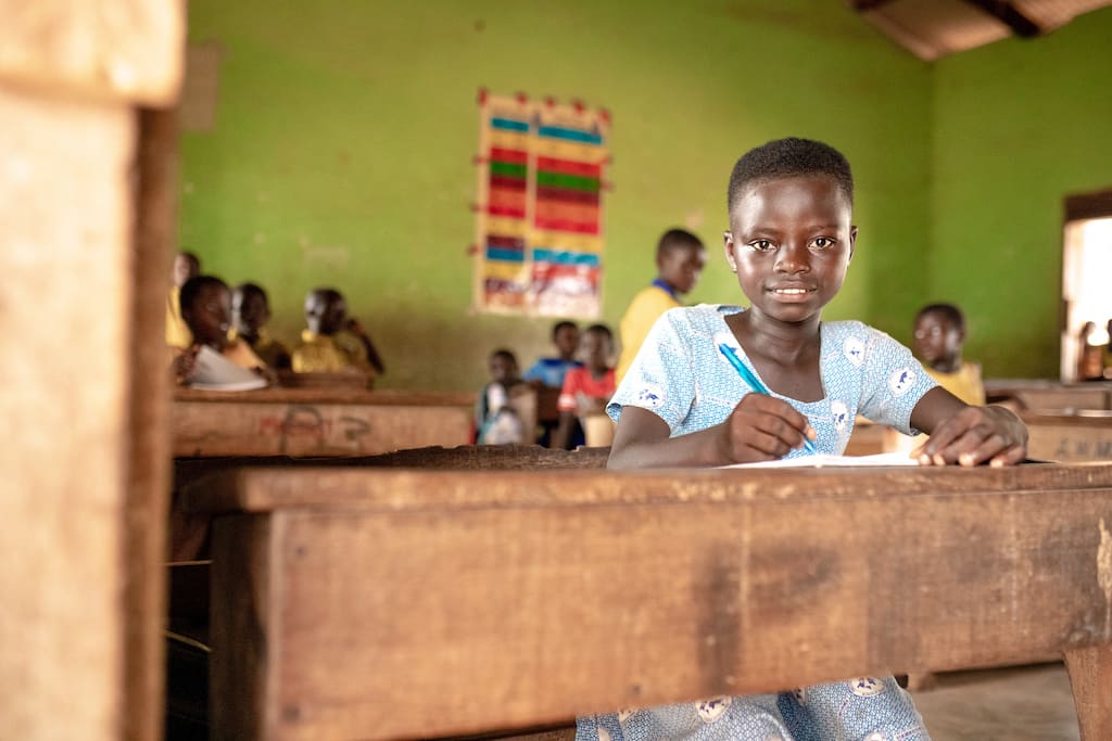 A student in Ghana sits at her desk.