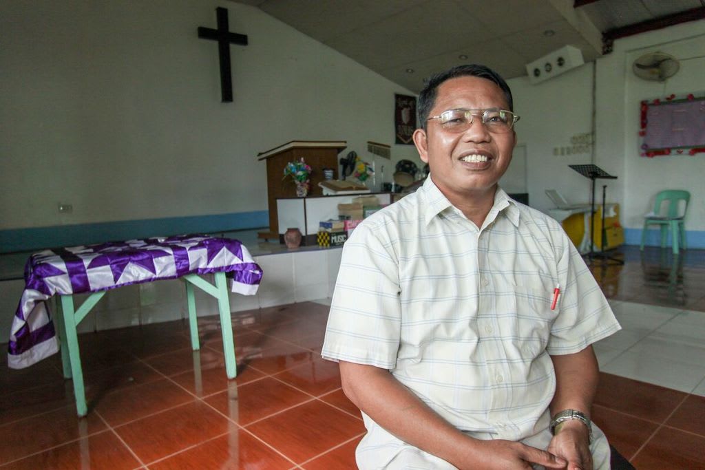 A Filipino pastor sits in his church's sanctuary.