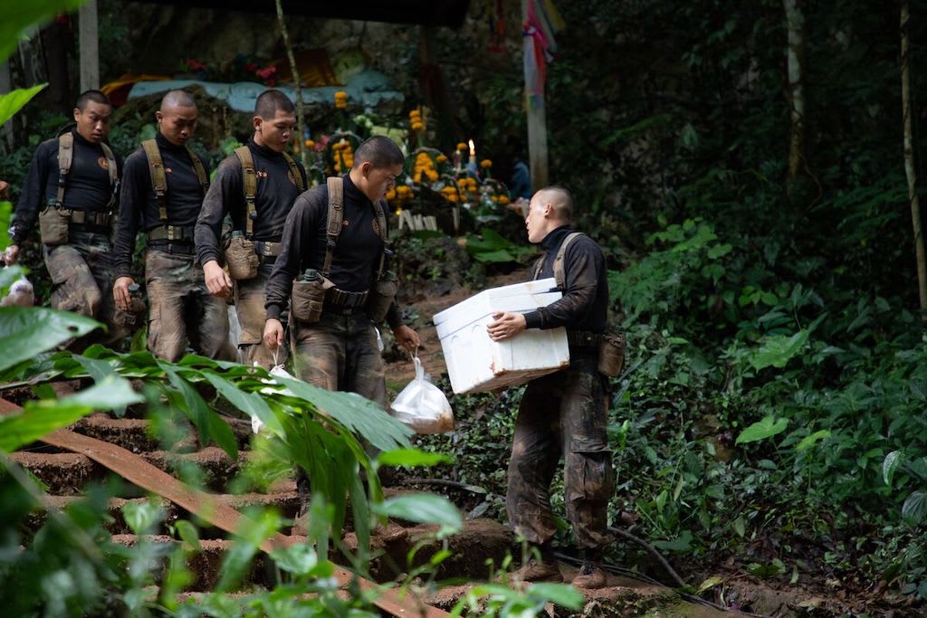 The Thai army and volunteers working to divert water away from the cave where the soccer team was trapped, as depicted in the film Thirteen Lives.