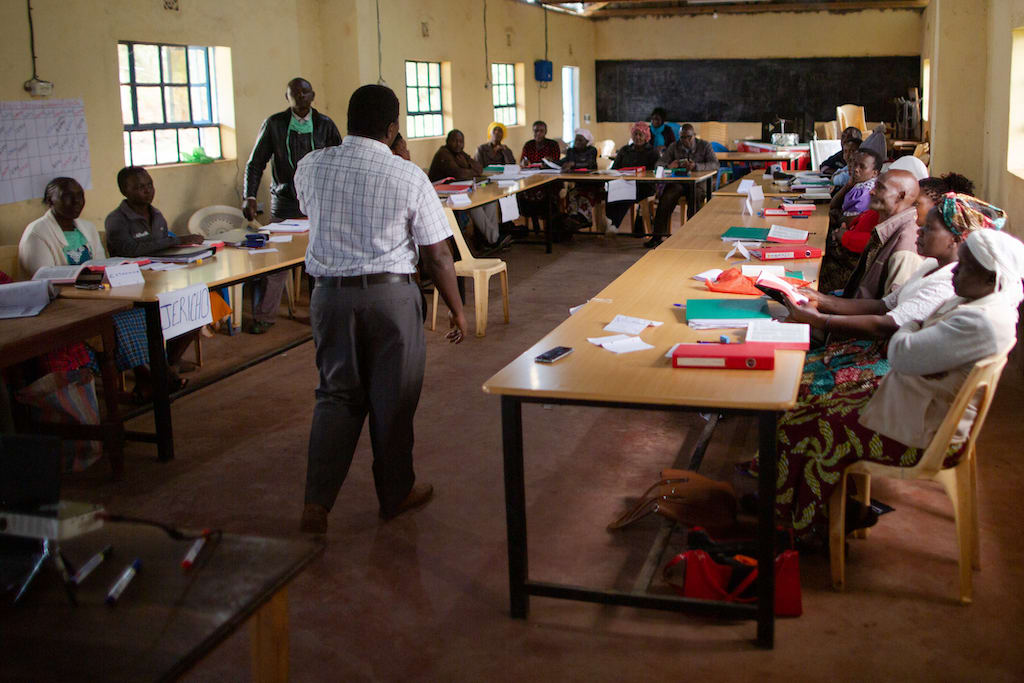 A group of adults in a classroom in Kenya.