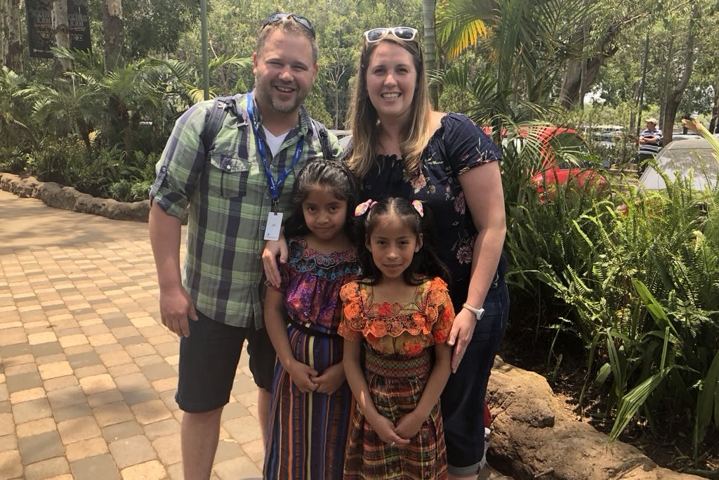 Jeff and Ruth with two Compassion-sponsored girls who are wearing traditional Indigenous dresses.