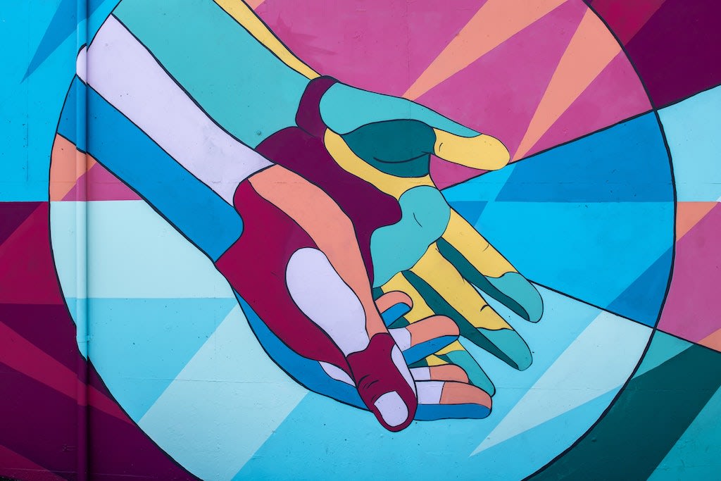 A colourful graffiti of hands reaching out
