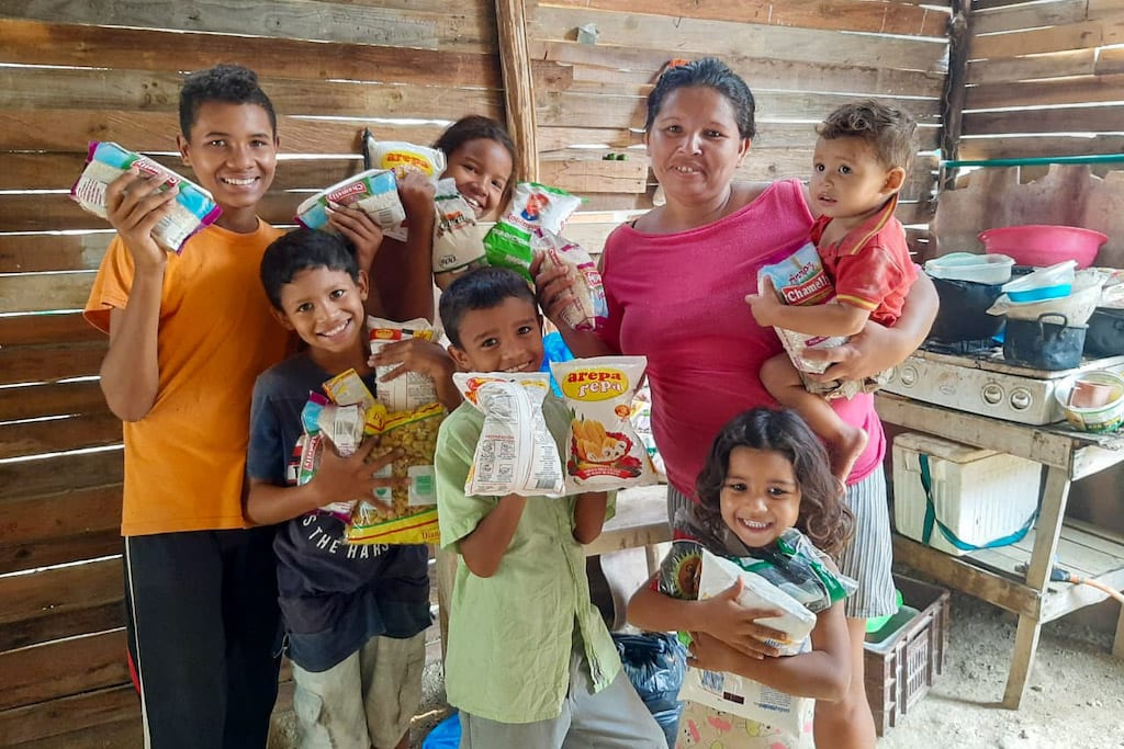 Gladys and her children with the groceries bought for them by the Compassion centre.