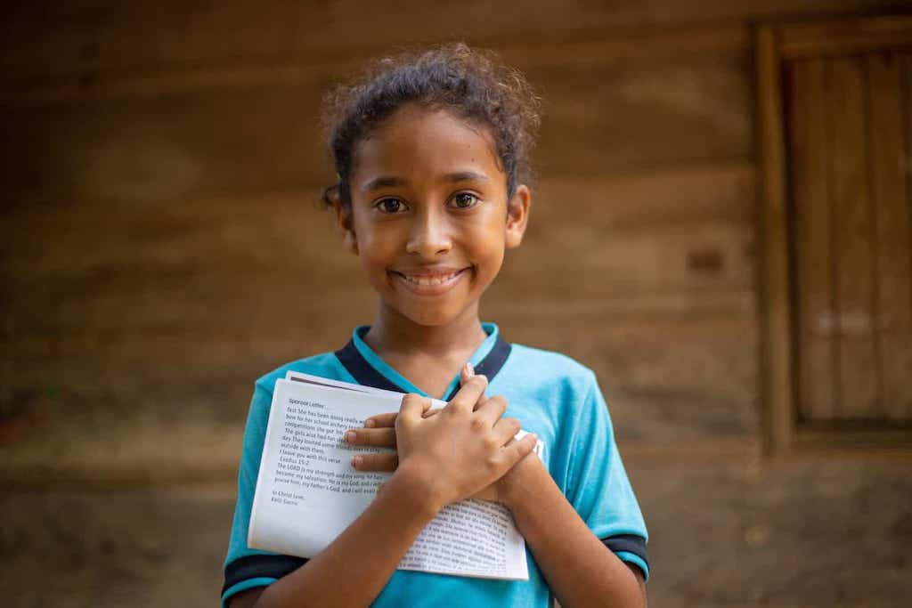 A girl clutches a letter to her chest.