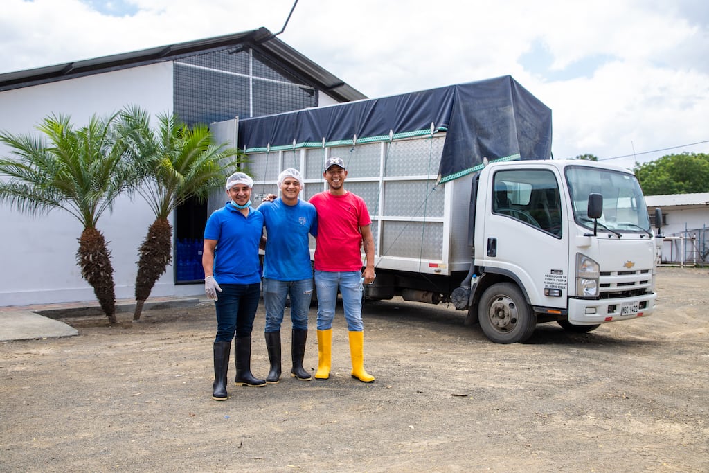 Leonardo, Joel and Cristian pose in front of a truck parked in front of the water plant.
